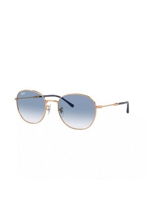 Occhiali da sole Ray-Ban con una montatura in metallo dorato, forma aviator, lenti blu sfumate e puntalini neri. Cuscinetti per il naso trasparenti e branding discreto.