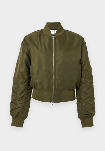 Χακί πράσινο bomber μπουφάν με φερμουάρ μπροστά, ριμπ γιακά, μανσέτες και μέση, με ελαφρώς ρυτιδιασμένα μακριά μανίκια.