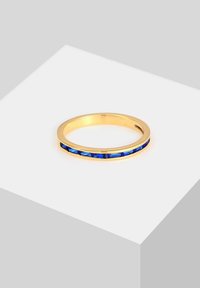 Goldring mit horizontaler Reihe blauer Edelsteine. Der Ring hat eine glatte, polierte Oberfläche und ein minimalistisches Design.