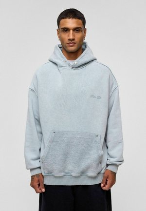 Lichtblauwe oversized hoodie van een gestructureerde stof, met een voorkantoor, ribgebreide manchetten en een capuchon met trekkoord.