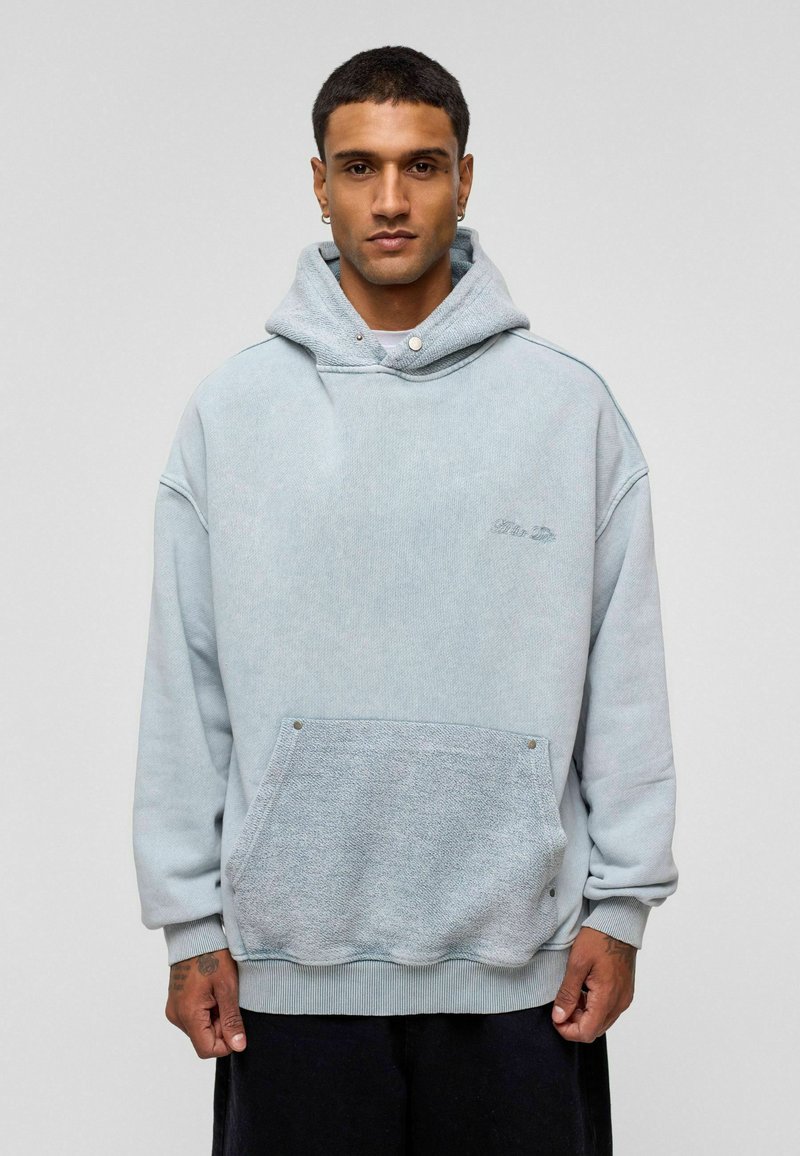 Lichtblauwe oversized hoodie van een gestructureerde stof, met een voorkantoor, ribgebreide manchetten en een capuchon met trekkoord.