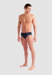 Svarta simbyxor med blå geometriska detaljer, med en tajt passform, slät textur och minimal täckning, designade för vattenaktiviteter.