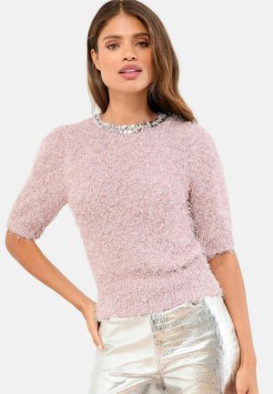 Rosa fluffig kortärmad tröja med en halsringning prydd med paljetter, i kombination med glänsande metalliska silverbyxor med ett strukturerat mönster.