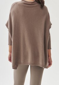 Brązowy, miękki sweter o luźnym kroju, z ryflowanymi detalami na rękawach. Okrągły dekolt i dłuższy tylny brzeg.