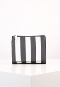 Borsa a pochette a strisce bianche e nere realizzata in pelle testurizzata, caratterizzata da una cerniera dorata e forma rettangolare, posizionata su una superficie bianca.