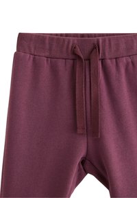 Vinfarvede sweatpants med ribbet talje, justerbar snor og blød tekstur. Har en tapered ben design for komfort.
