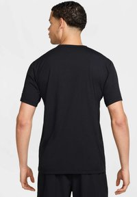 Zwarte short-sleeve T-shirt met een ronde hals, een gladde textuur en een relaxte pasvorm. De achterkant heeft een eenvoudig ontwerp zonder zichtbare logo's of accenten.