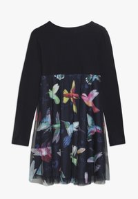 Czarna sukienka z długim rękawem, z kolorowym nadrukiem kolibra na części spódnicy oraz jednoczęściowym czarnym gorsetem.