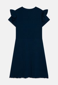 Bawełniana sukienka w kolorze granatowym, z krótkimi falbankowymi rękawami, prążkowaną fakturą na dolnej połowie i surowym wykończeniem dołu. Prosty okrągły dekolt.