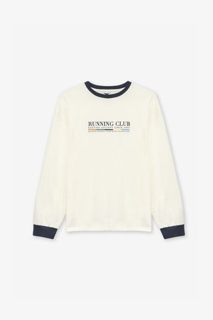 Camiseta de manga larga color crema con acentos en azul marino, que presenta el texto "RUNNING CLUB" y una textura suave y ligera.