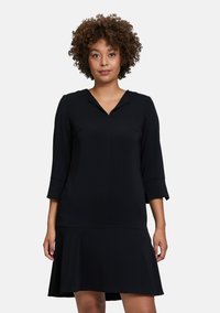 Schwarzes Kleid mit Dreiviertelärmeln, V-Ausschnitt, A-Linie-Silhouette, glatter Textur, knielang, ohne sichtbare Muster oder Verzierungen.