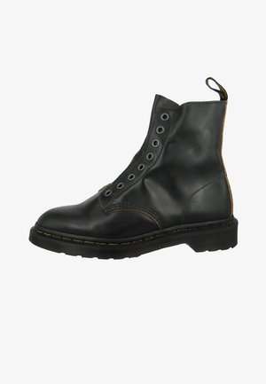 Stivaletto in pelle nera con punta rotonda, chiusura stringata e occhielli metallici. Presenta cuciture a contrasto e una suola in gomma testurizzata.
