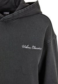 Felpa con cappuccio grigio scuro in cotone con finitura texture. Presenta una tasca frontale e il logo 'Urban Classics' ricamato in bianco.