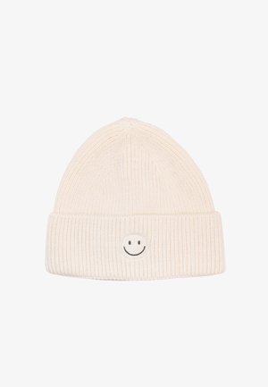 White knitted beanie with ribbed texture and folded cuff, featuring a simple black smiley face emblem on the front.