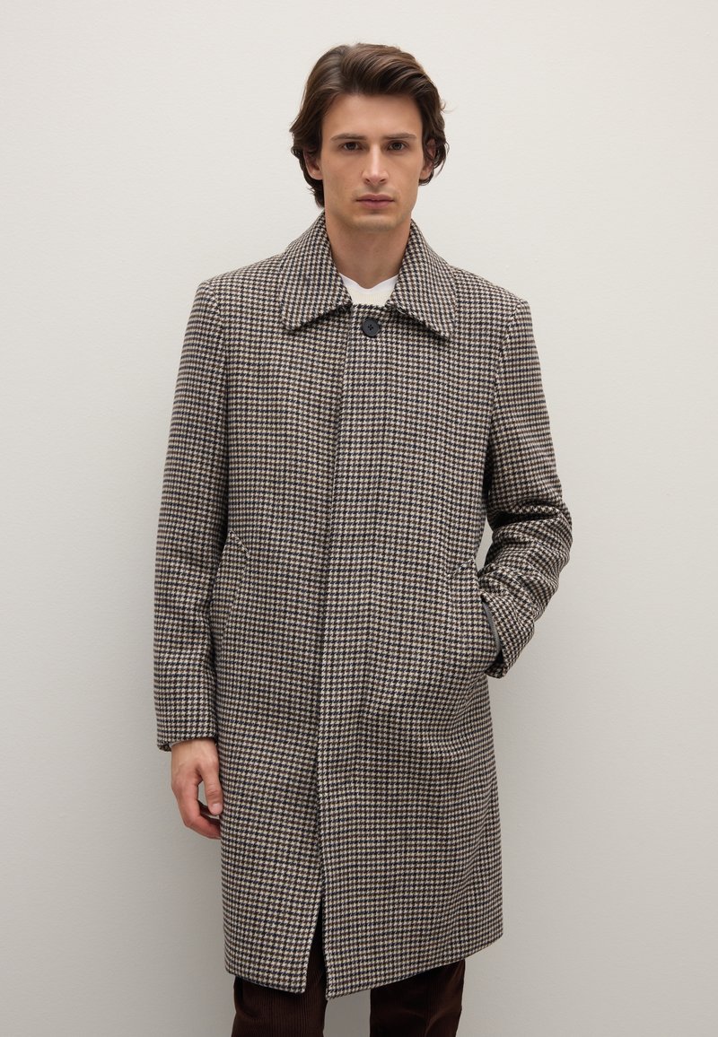 Braun-weiß kariertes Hahnentrittmuster Mantel mit Kragen, zwei Taschen vorne und Knopfverschluss. Hergestellt aus strukturiertem Stoff.