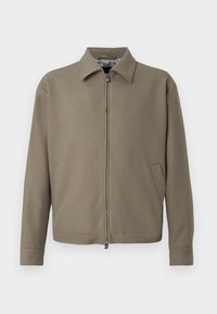 Veste zippée kaki avec col, fabriquée en tissu lisse. Dispose de poches latérales et d'un design épuré et minimaliste.