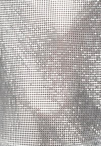 Αντανακλαστικές ασημένιες παγιέτες τοποθετημένες σε ένα πλέγμα, δημιουργώντας μια λαμπερή, υφή επιφάνεια με ποικίλες αντανακλάσεις φωτός.