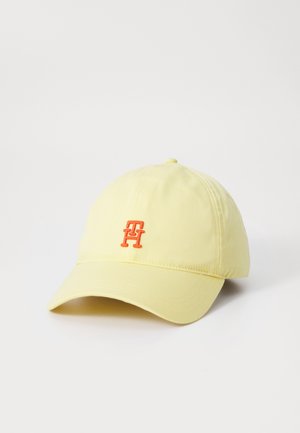Casquette de baseball jaune clair avec visière incurvée et petit logo brodé "TH" orange au centre devant.