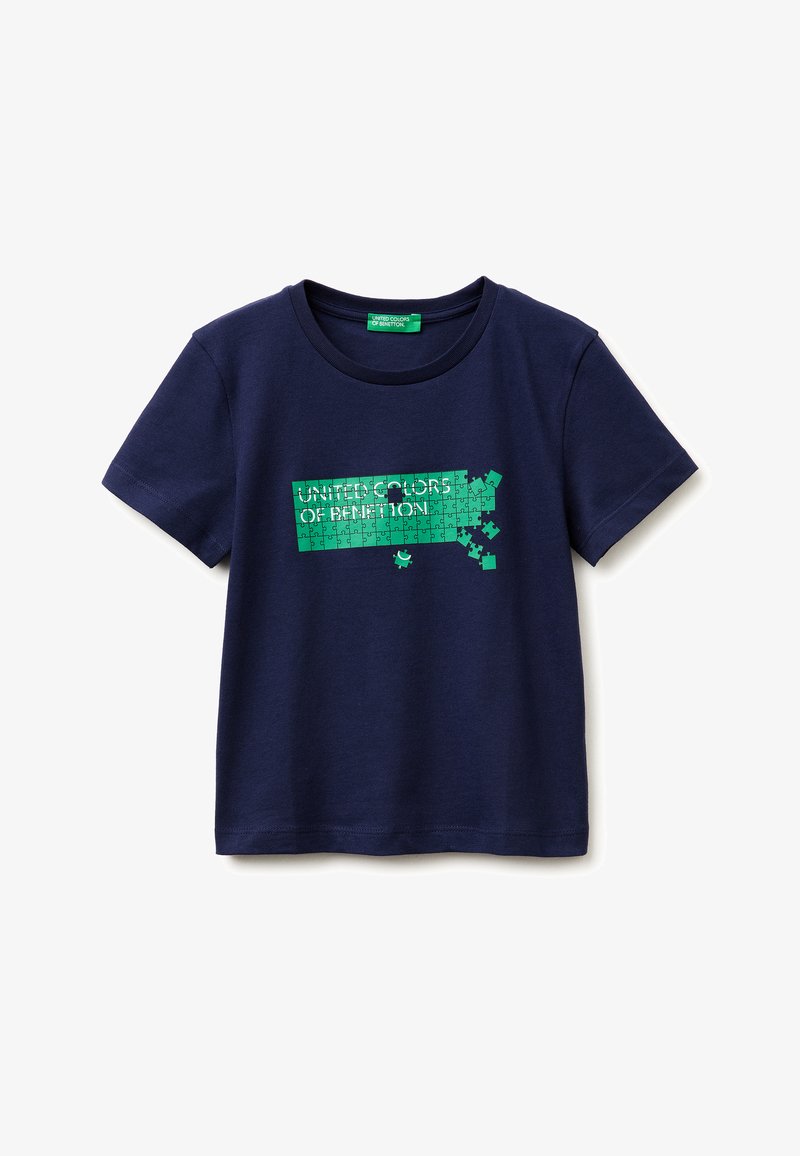 T-shirt bleu marine à manches courtes avec col rond, présentant un motif puzzle vert avec quelques pièces manquantes et le texte "United Colors of Benetton".