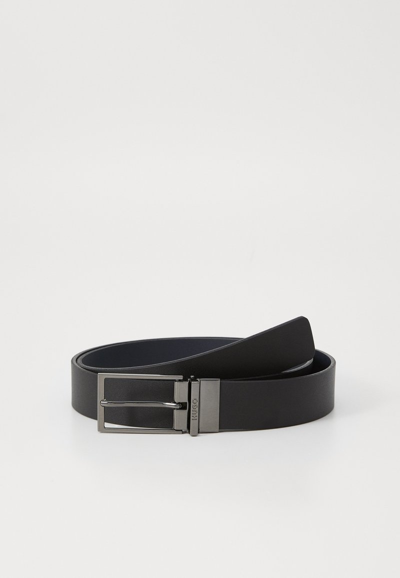 Ceinture en cuir noir au fini lisse, dotée d'une boucle en métal argenté de forme rectangulaire et d'une fermeture à ardillon.