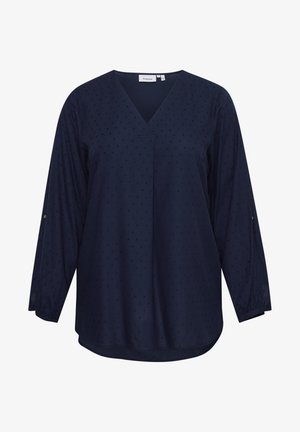 Navy blue long-sleeve blouse featuring a V-neck and textured dot pattern. Soft fabric with elastic cuffs and a rounded hem.