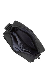 Borsa in tessuto nero con chiusura a zip, caratterizzata da un ampio interno con più scomparti e una fodera grigia liscia.