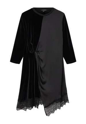 Abito in velluto nero con dettaglio a nodo su un lato, caratterizzato da un tessuto liscio e un bordo in pizzo lungo l'orlo, che offre una texture contrastante.
