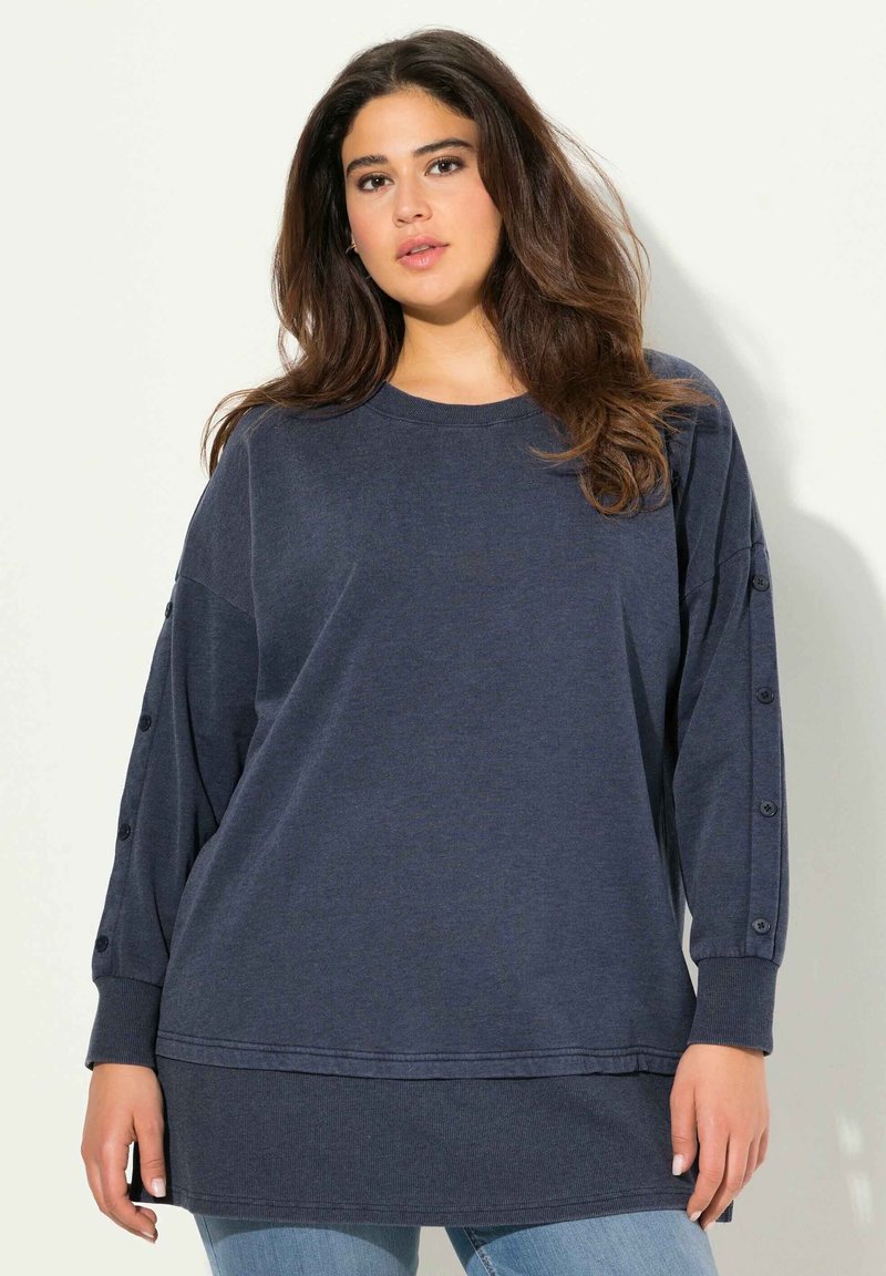Felpa oversize blu navy scuro realizzata in materiale morbido, con maniche lunghe abbellite da bottoni e un design con orlo a strati.