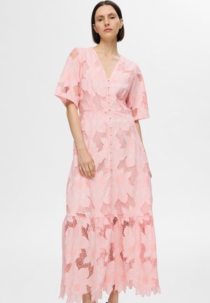 Pink lace dress with floral pattern, short sleeves, V-neck, and button front. Features a tiered hemline with scalloped edges.