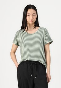 Gestreifte T-Shirt in Grün und Weiß mit rundem Halsausschnitt und hochgekrempelten Ärmel, kombiniert mit schwarzen Jogginghosen mit Kordelzug. Weiche Stoffqualität.