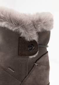 Stivale in suede marrone per l'inverno con collare in pelliccia sintetica grigia chiara e dettaglio con chiusura regolabile a toggle sul lato.