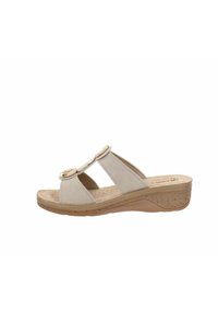 Sandali con zeppa beige con due cinture larghe, dotati di hardware rotondi decorativi e una suola in sughero testurizzato per comfort e stabilità.
