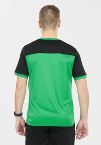 Vihreä ja musta urheilu-takki, jossa on lyhyet hihat, musta yläosa ja sileä, kosteutta siirtävä kangas.