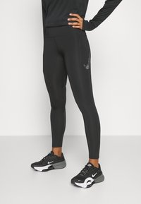 Černé sportovní legíny vyrobené z elastické tkaniny s hladkým povrchem. Mají decentní šedé logo Nike na boku a vysoký pas.