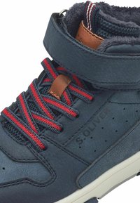 Baskets montantes bleu marine en cuir texturé, avec des lacets rouges, un accent en cuir marron, une doublure douce et des détails perforés sur le côté.