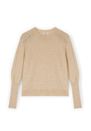 Maglione beige in maglia con scollo rotondo, maniche a sbuffo, orlo a costine e applicazioni di borchie sulle spalle. Texture morbida e design aderente.