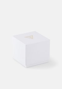 Cutie alba cu o suprafață texturată, având un logo în formă de triunghi auriu deasupra. Design minimalist, închis cu un capac pliabil.