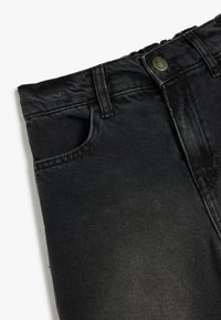 Jeans in denim nero con taglio dritto, caratterizzati da una tasca frontale, cuciture a vista e un bottone in metallo in vita. Tessuto testurizzato.