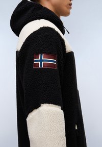 Sort og creme fleece hoodie med en struktureret ydre, der har et norsk flag patch på ærmet. Inkluderer en hætte med snor.