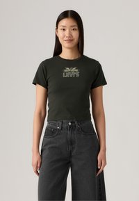 Tmavě zelené zkrácené tričko s krátkým rukávem, se světlou grafikou "Levi's". V kombinaci s vysokými černými džínami.