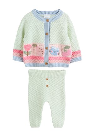 Blødt pastel strikket babyoutfit med cardigan med knapper med blomstermønstre og dyremotiver, matchet med teksturerede bukser med to forreste knapper.