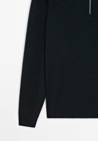 Zwarte gebreide trui met een hoge kraag en halve rits, met lange mouwen en een slim fit, gemaakt van een zachte, gestructureerde stof.