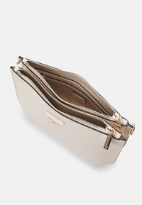 Borsa a mano beige con zip e dettagli dorati, dotata di più scomparti e una superficie esterna liscia e testurizzata. Logo sul pannello frontale.