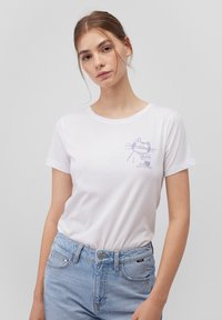 White cotton t-shirt featuring a light purple cat graphic with whiskers and a drink, crew neck design, short sleeves, and relaxed fit.