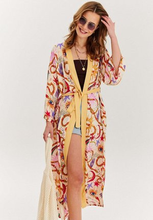 Barevný, vzorovaný kimono s květinovými a abstraktními motivy, se žlutým páskem, širokými rukávy a lehkým materiálem.