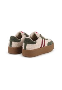 Zapatillas con una textura ligeramente esponjosa en color beige, detalles de ante verde, rayas rojas y una suela de goma marrón. Presenta cierre de cordones y una superficie texturizada.