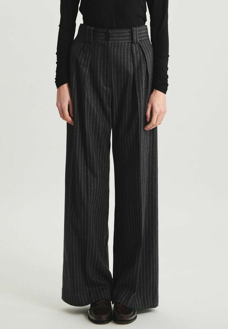 Pantalons à jambes larges gris foncé avec des rayures verticales. Fabriqués à partir d'un tissu texturé, ils présentent une taille haute et des plis.