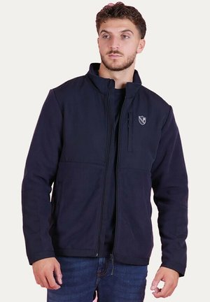 Veste en polaire bleu marine avec fermeture éclair, col haut et logo sur la poitrine gauche. Dispose de deux poches avant et d'un tissu doux et texturé.