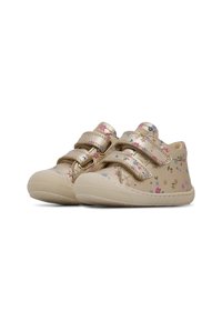 Chaussures pour tout-petits en cuir beige avec des motifs floraux, deux sangles Velcro et des semelles en caoutchouc texturées. Design à bout rond, profil bas.