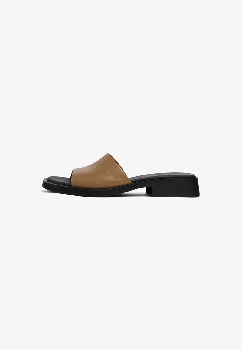 Sandale mule en cuir marron avec un petit talon bloc noir et une semelle plate, vue de profil sur fond blanc.